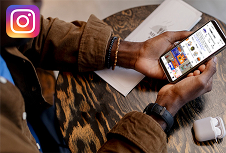 Hand holding smartphone browsing Third Dimension Instagram channel